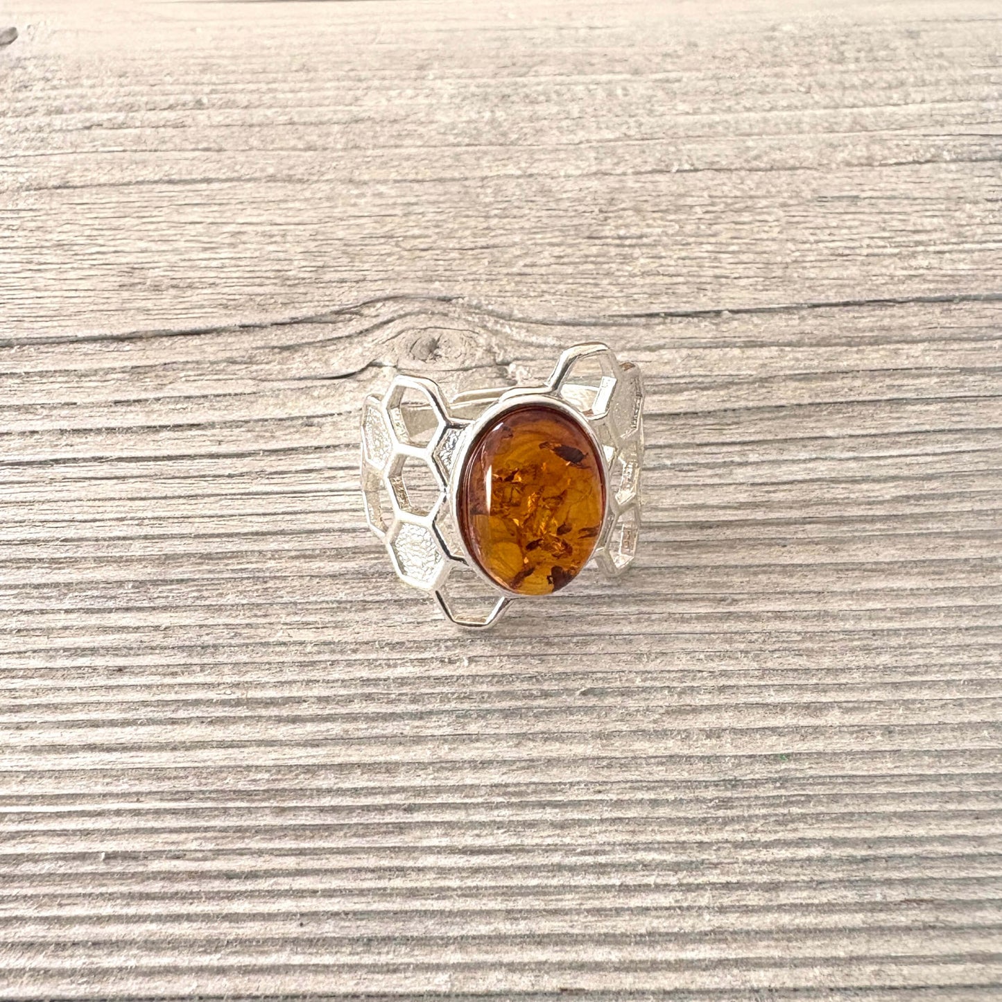 Silver ring with a amber stone on a wooden surface