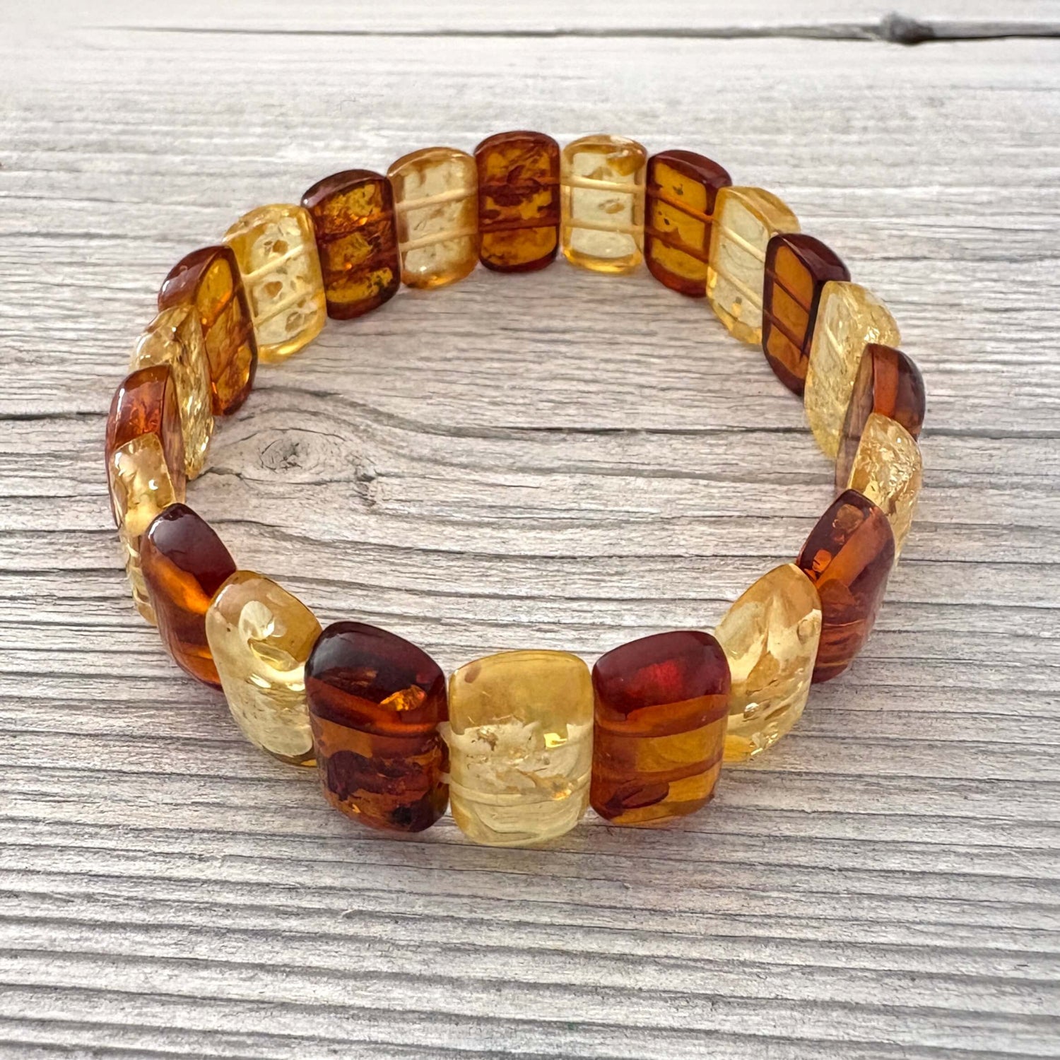 Beaded bracelet with amber-colored beads on a wooden surface