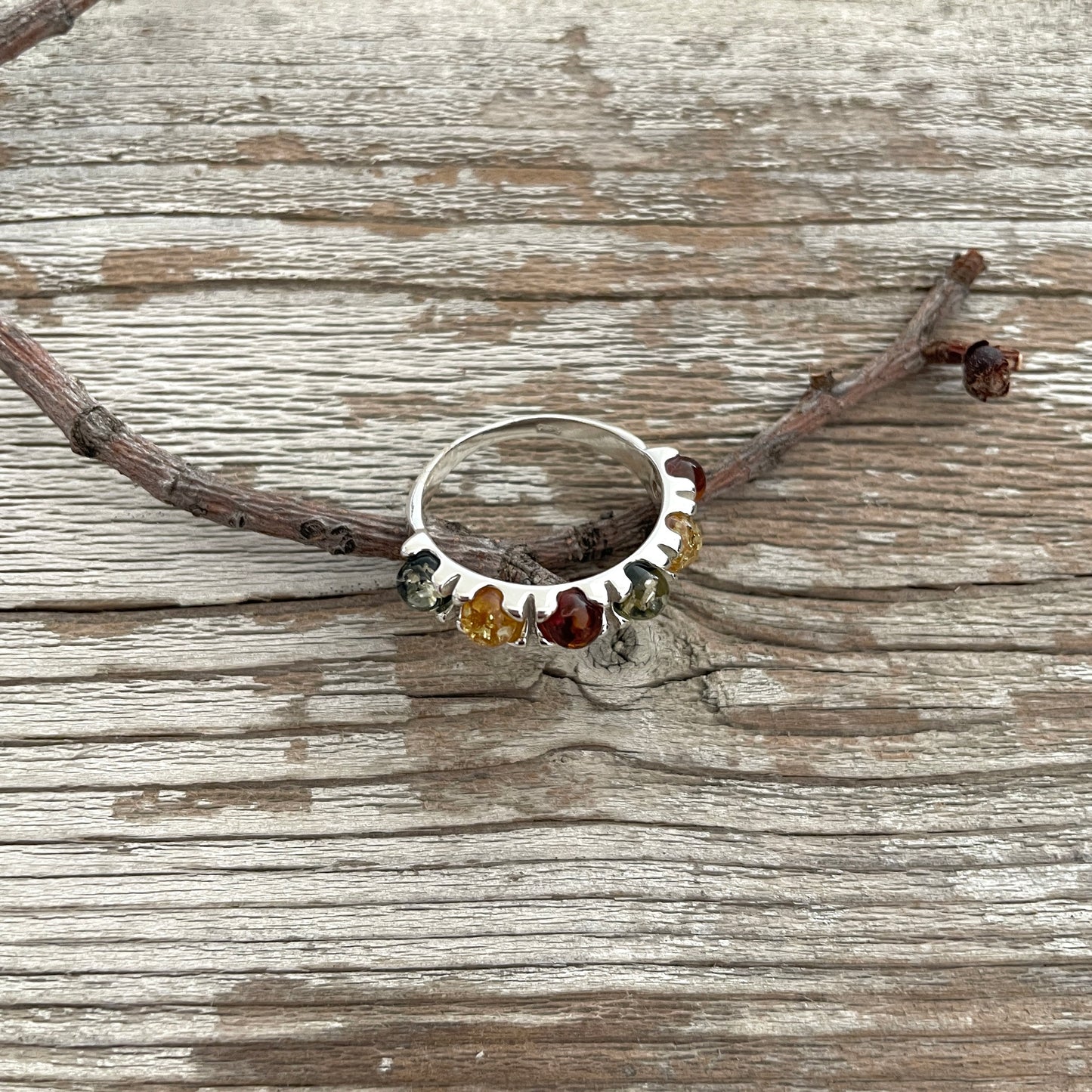 green, yellow and cognac amber round stones set in a sterling silver band