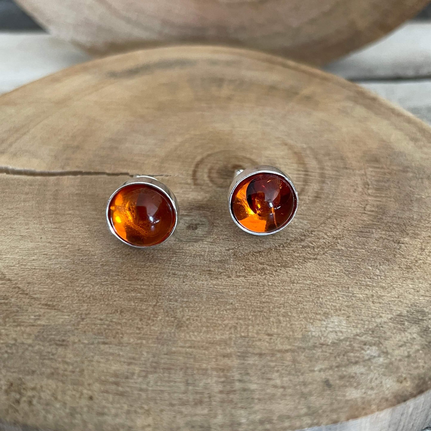 Amber stud earrings on a wooden surface