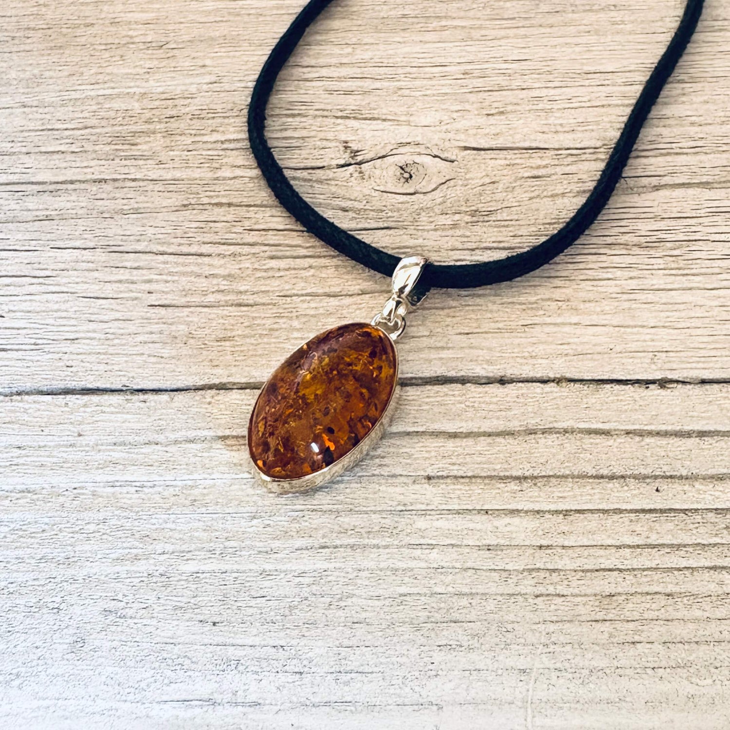 oval shaped cognac amber pendant set in sterling silver side angle