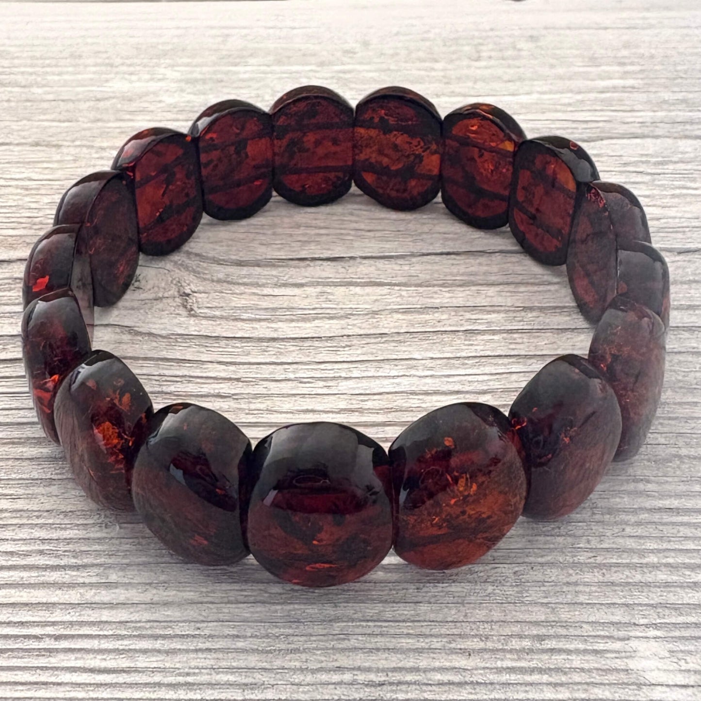 Cognac beaded bracelet on a textured light gray background