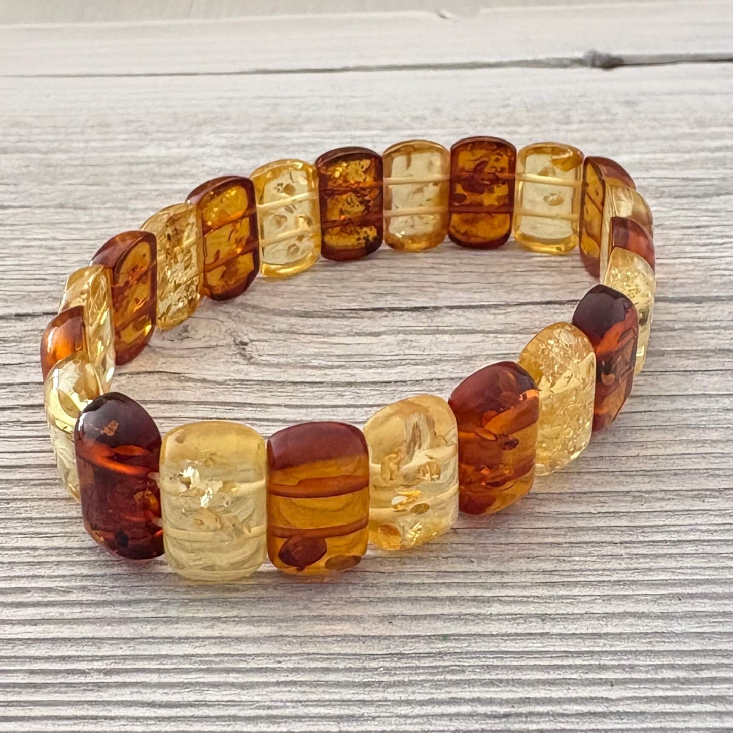 Beaded bracelet with amber-colored beads on a wooden surface