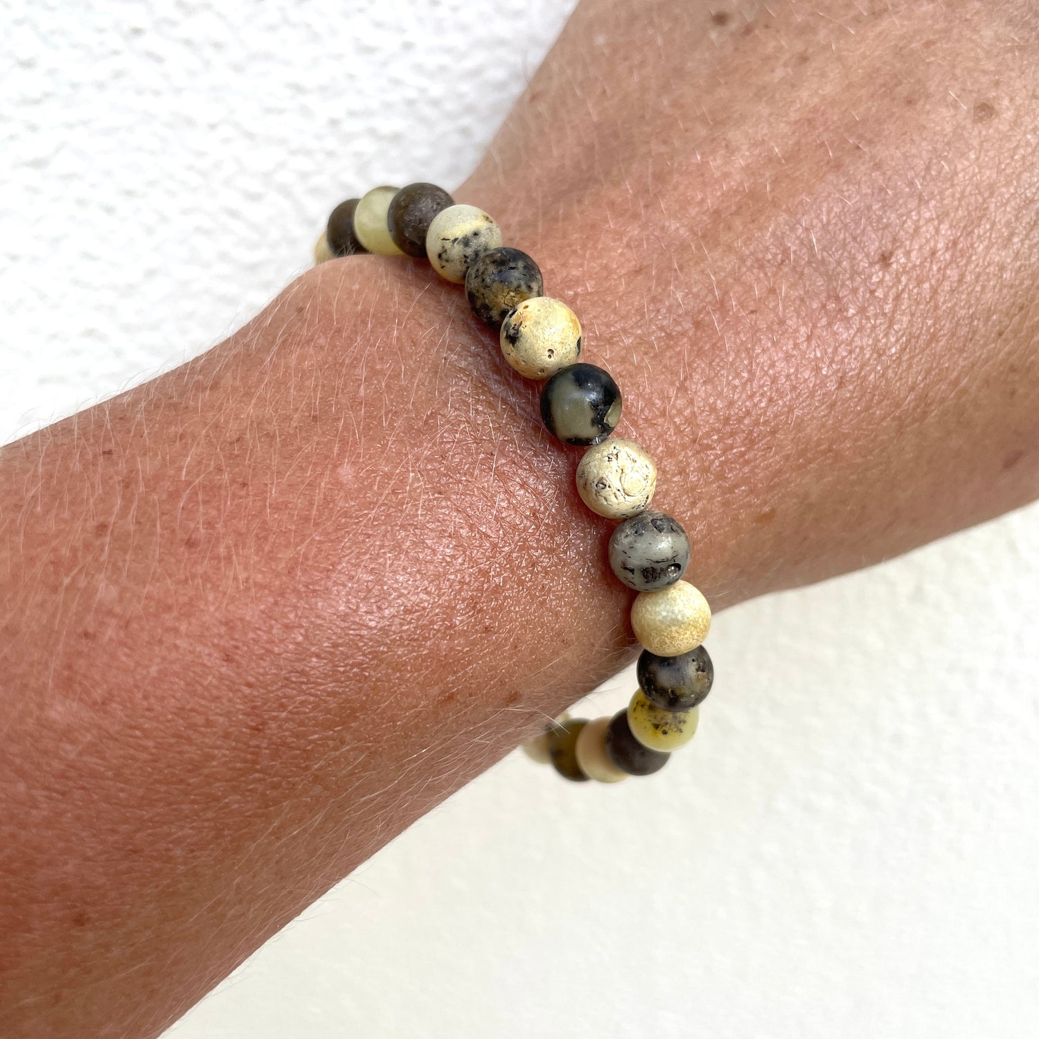 raw mixed coloured amber bracelet on wrist