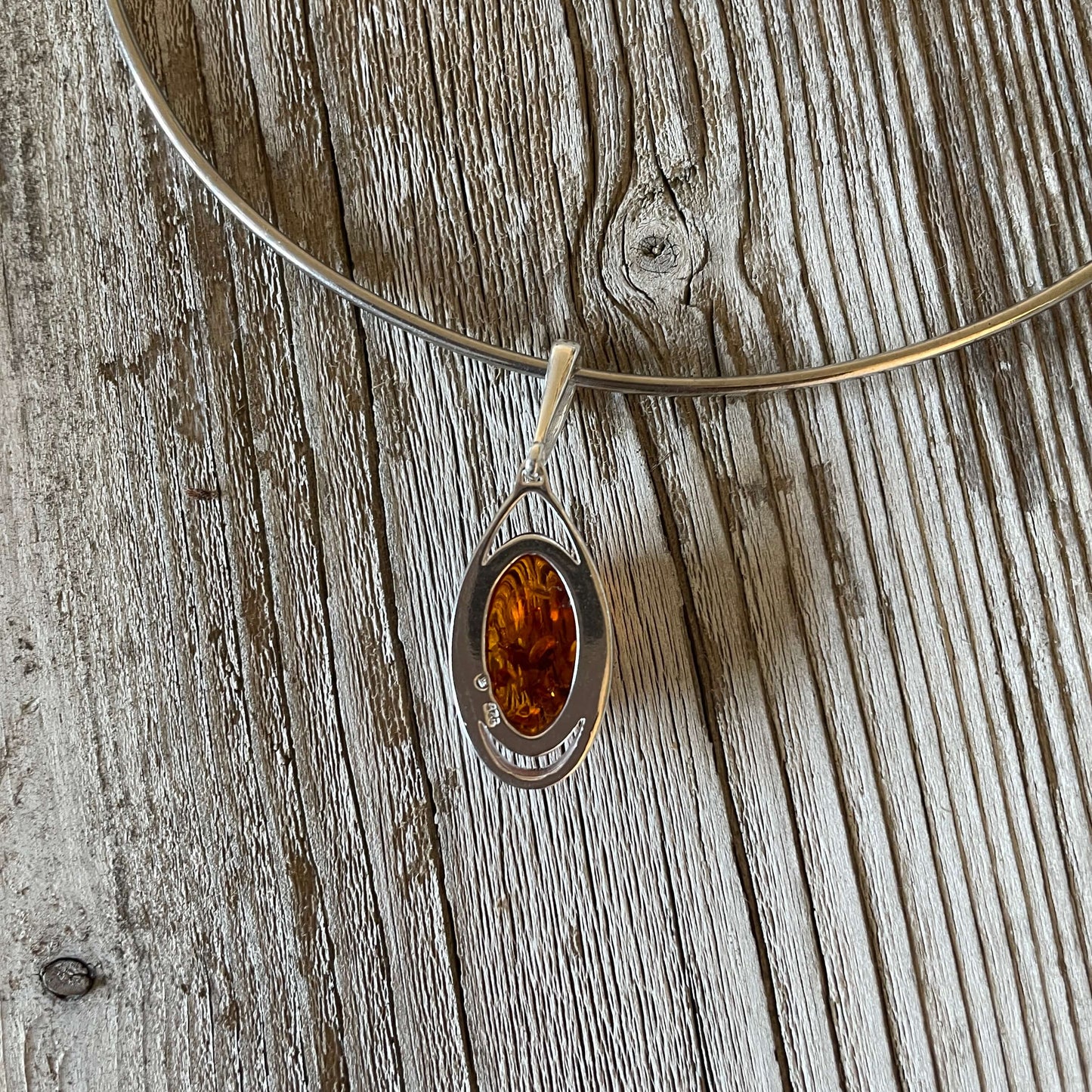 oval shaped cognac amber pendant set in sterling silver