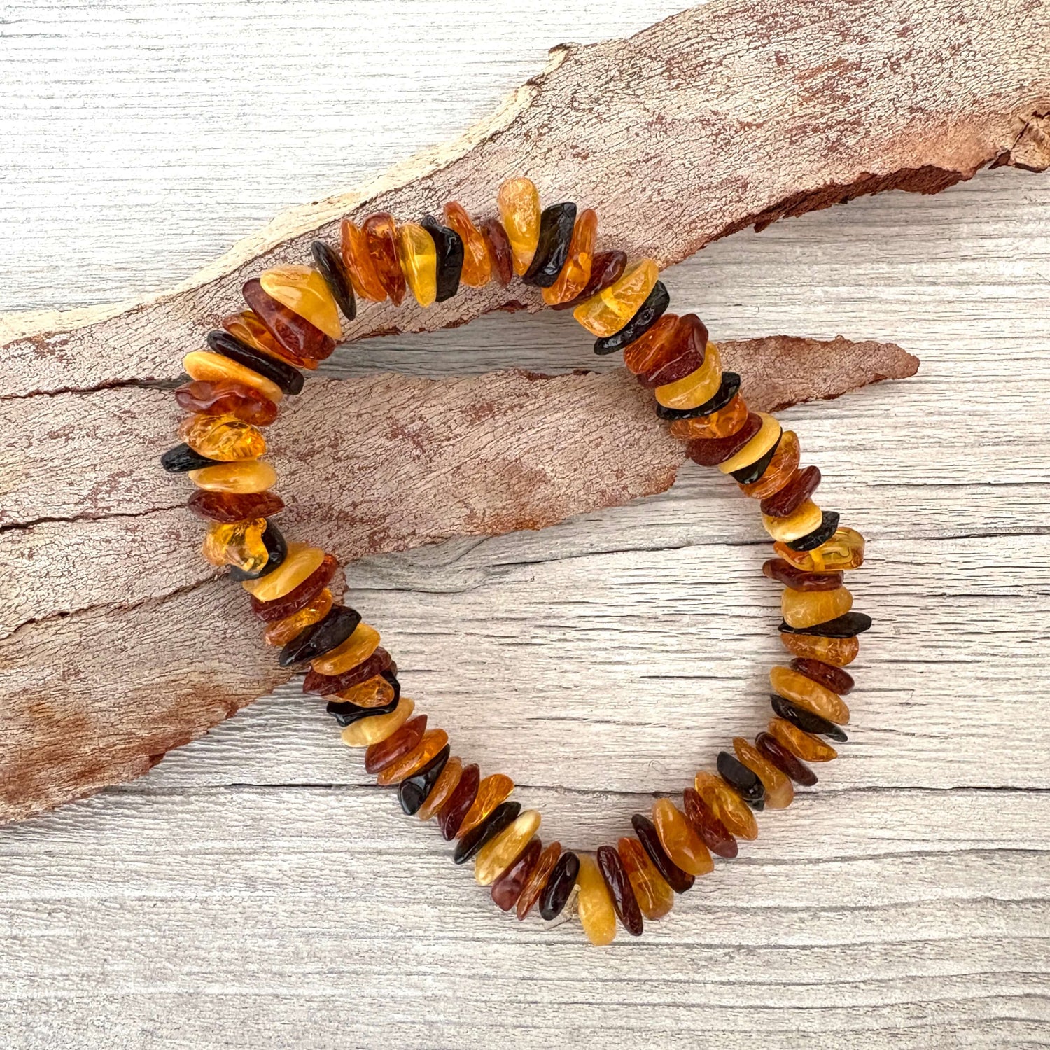 Multicolored amber bead bracelet on a wooden surface