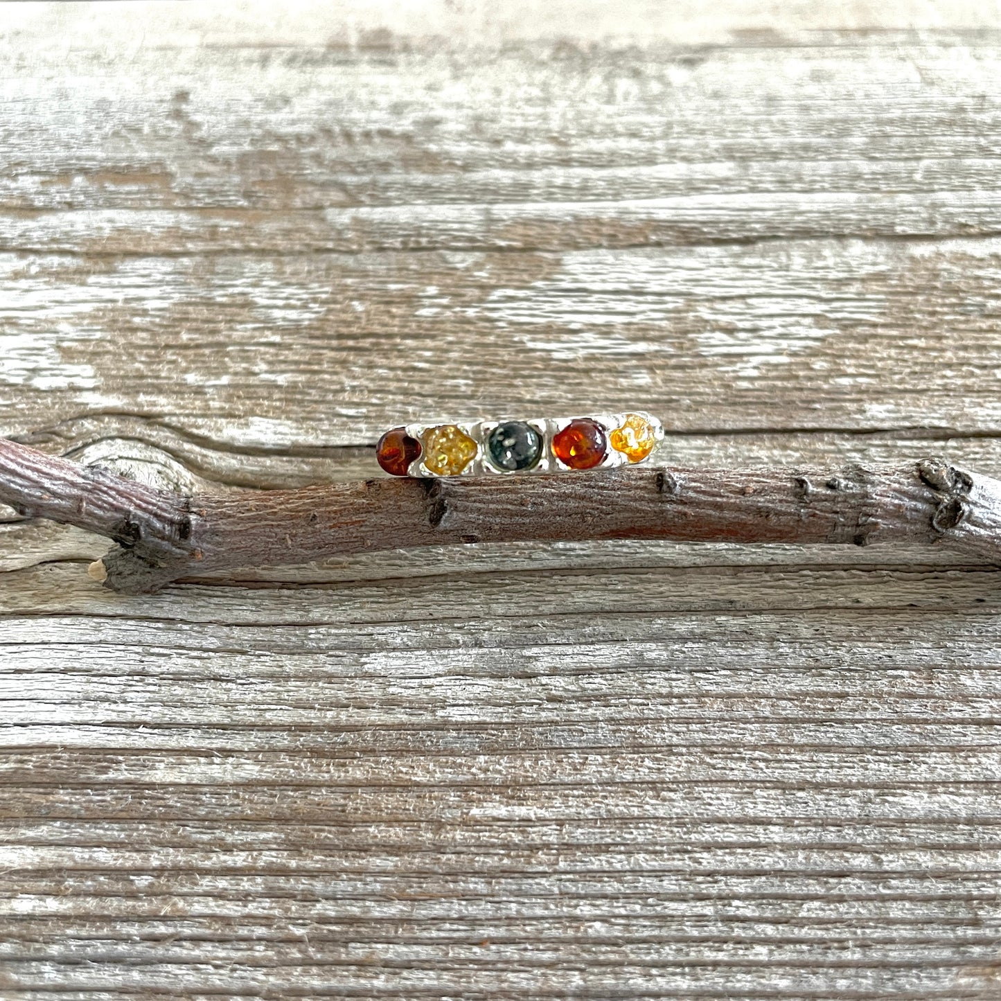 green, yellow and cognac amber round stones set in a sterling silver band