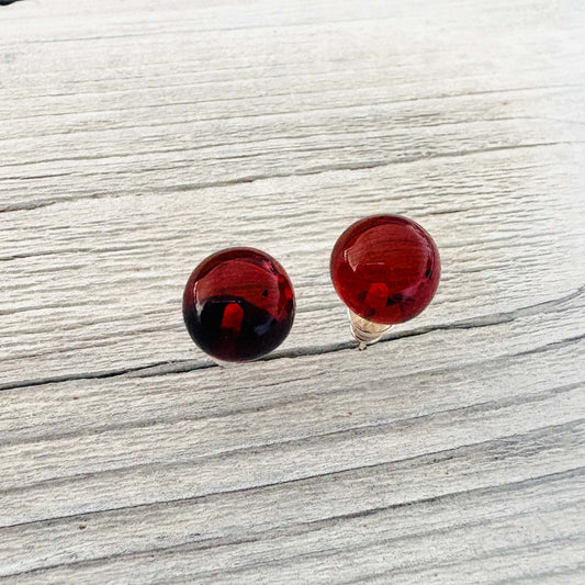Round cognac earrings on a light wooden surface