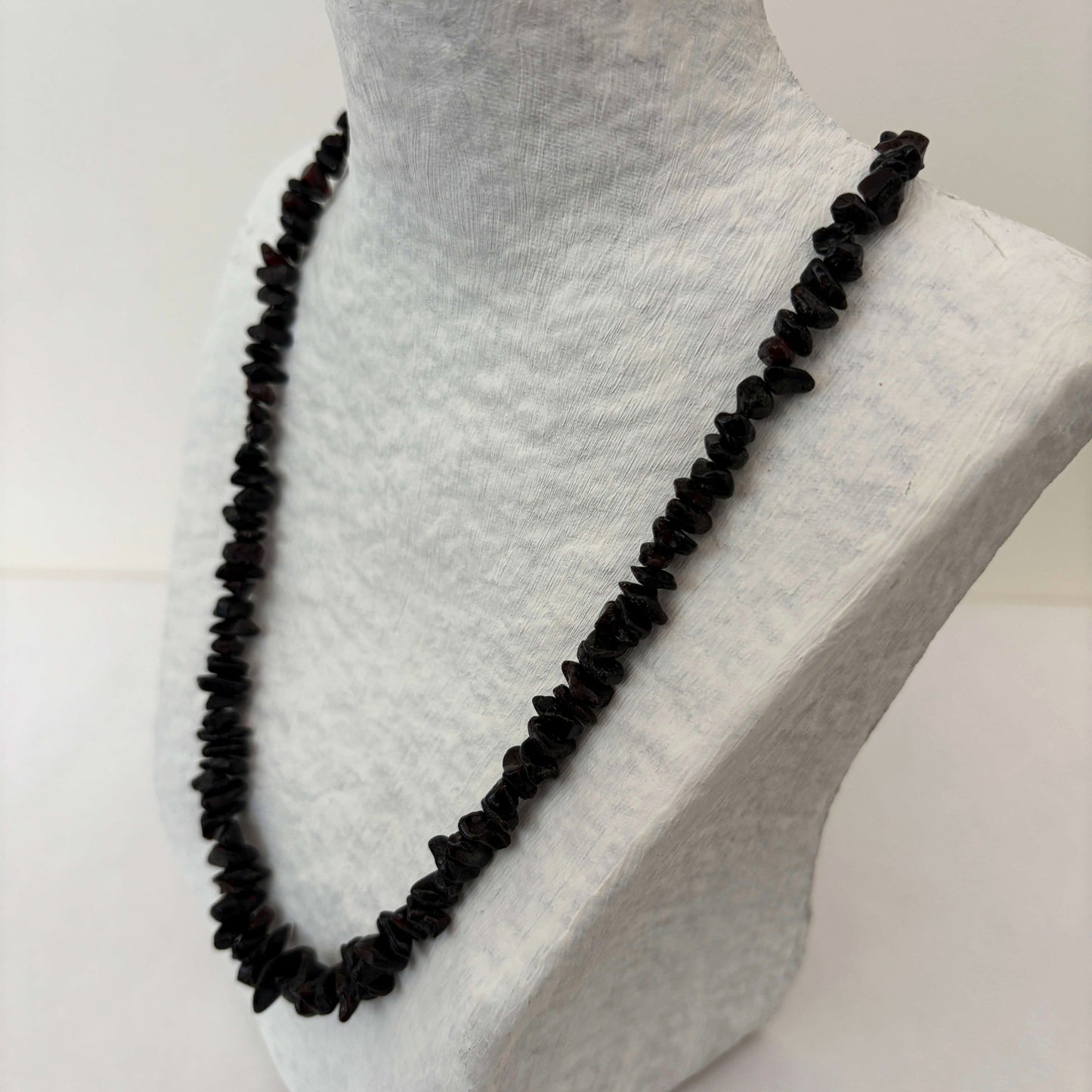 Cherry beaded amber necklace on a mannequin with a white background