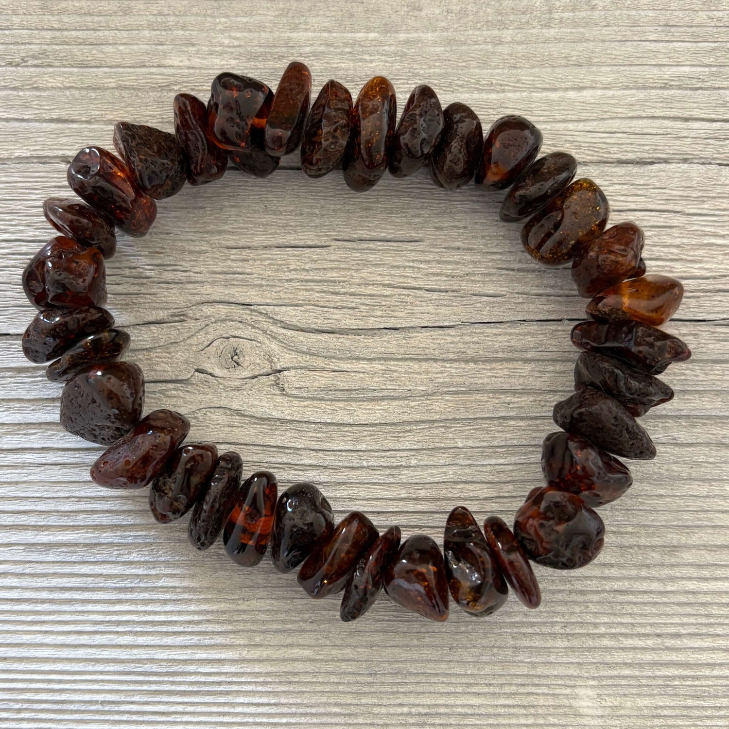 Beaded bracelet made of dark brown stones on a wooden surface