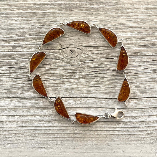 half moon shaped amber bracelet set in sterling silver with a lobster claw