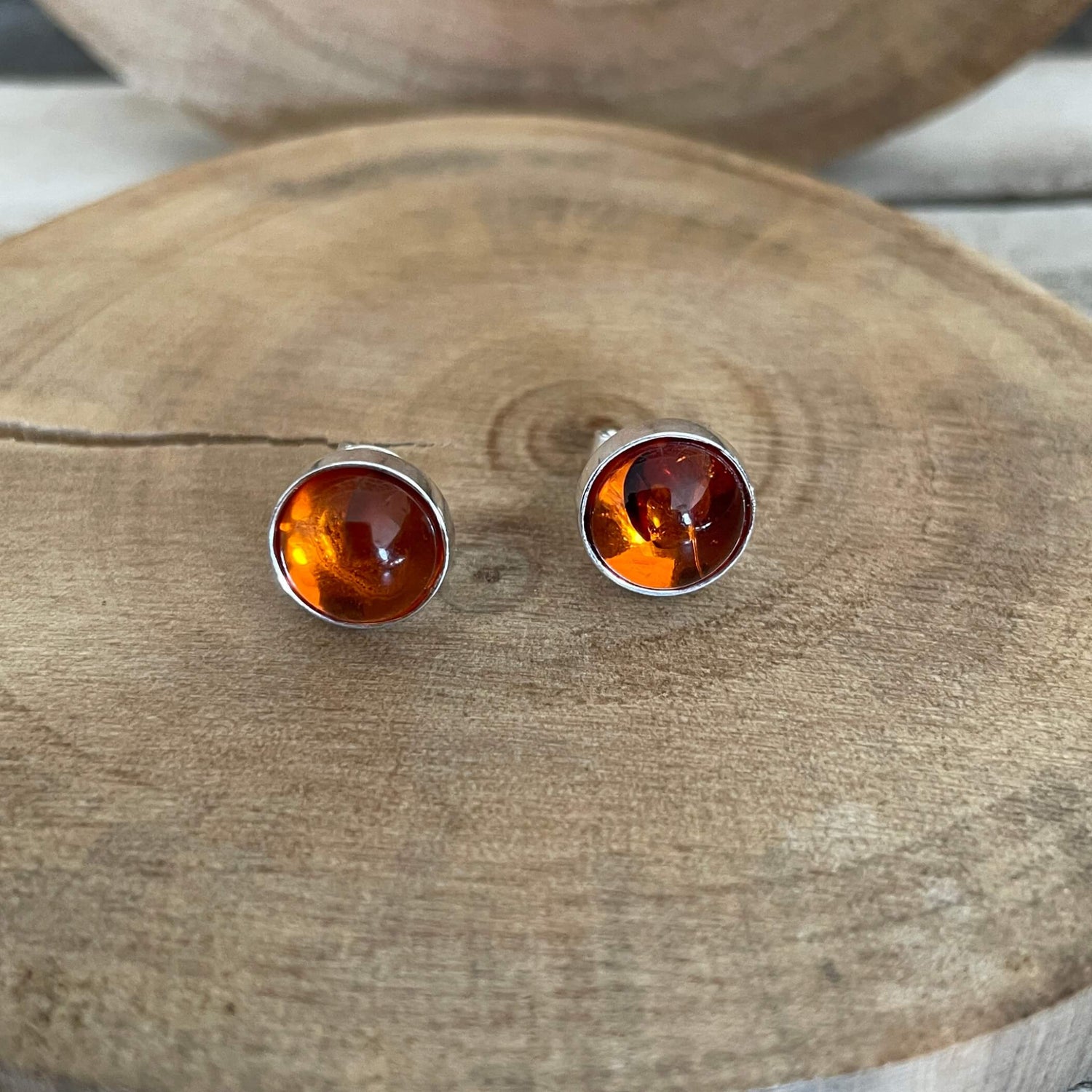 Amber stud earrings on a wooden surface