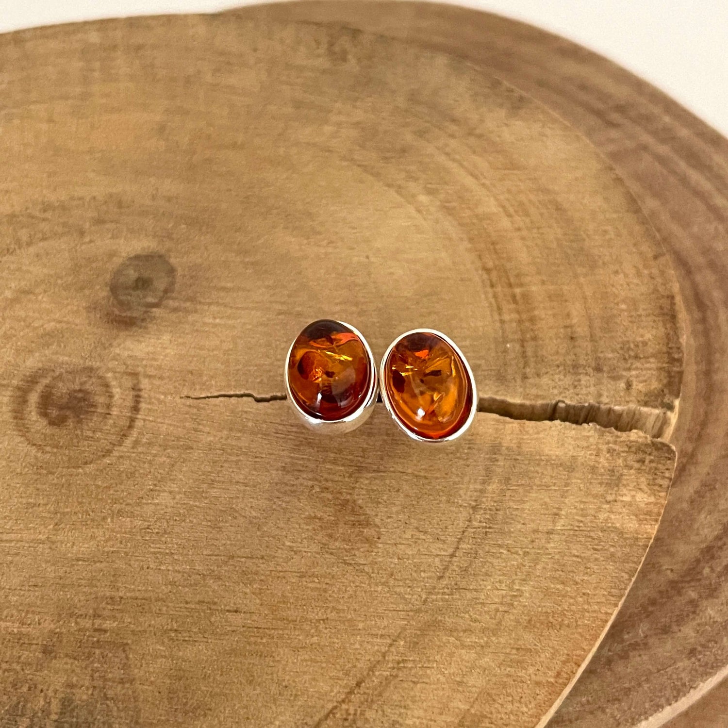 Pair of amber stud earrings on a wooden surface