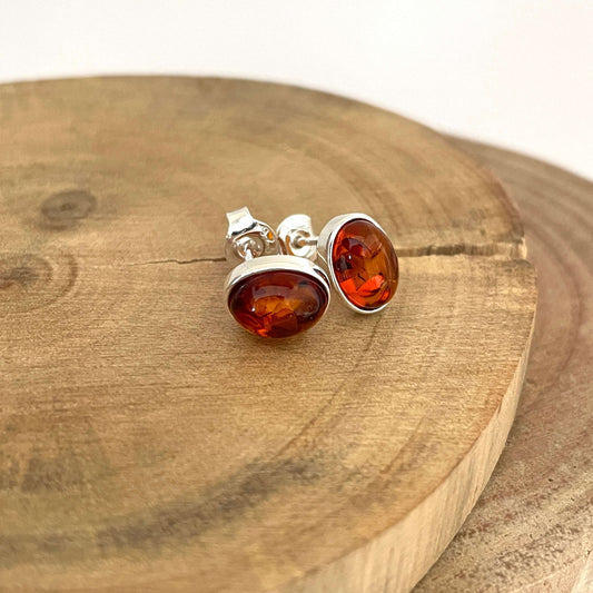 Silver earrings with amber stones on a wooden surface