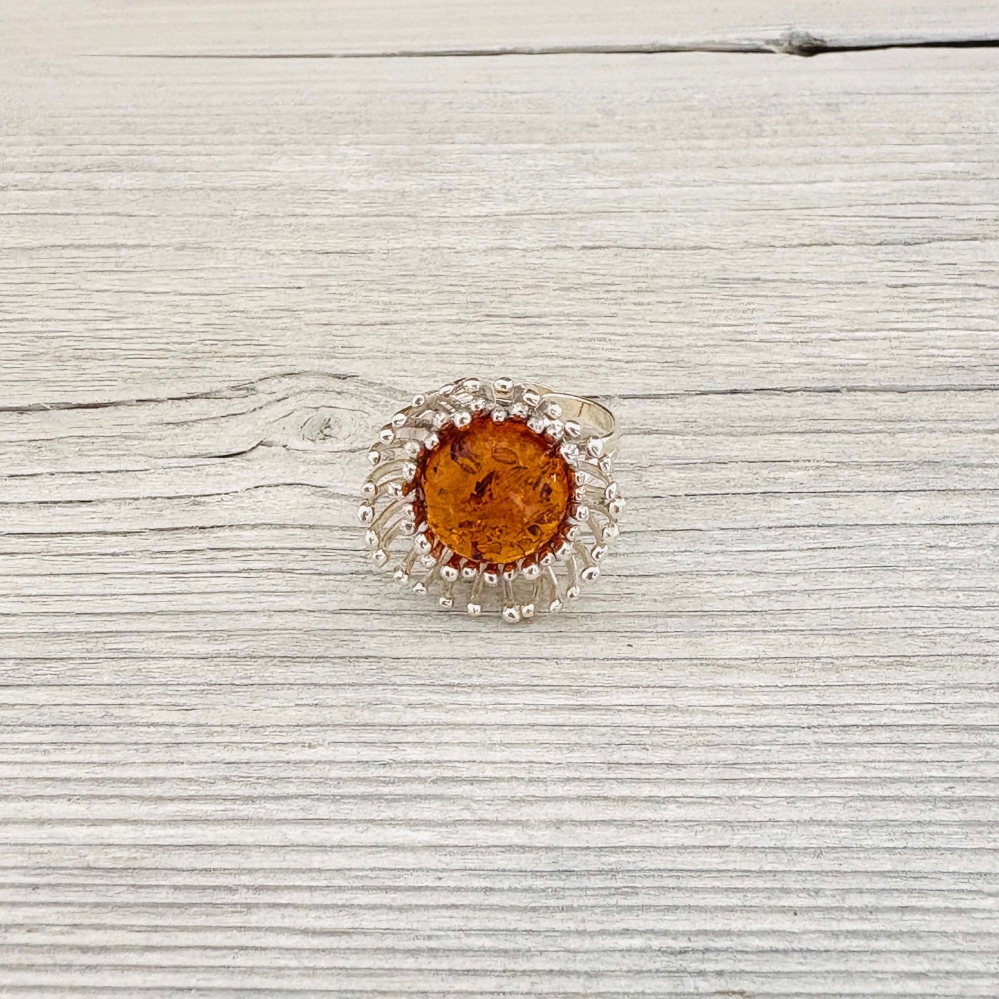 round cognac amber stone set in a sterling silver flower shaped and