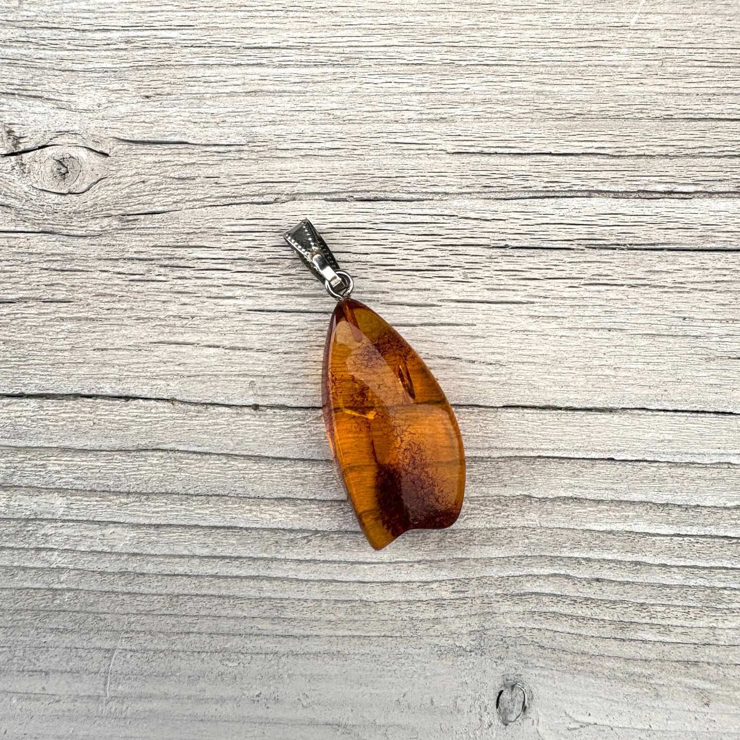 Baltic amber pendant with a timber background