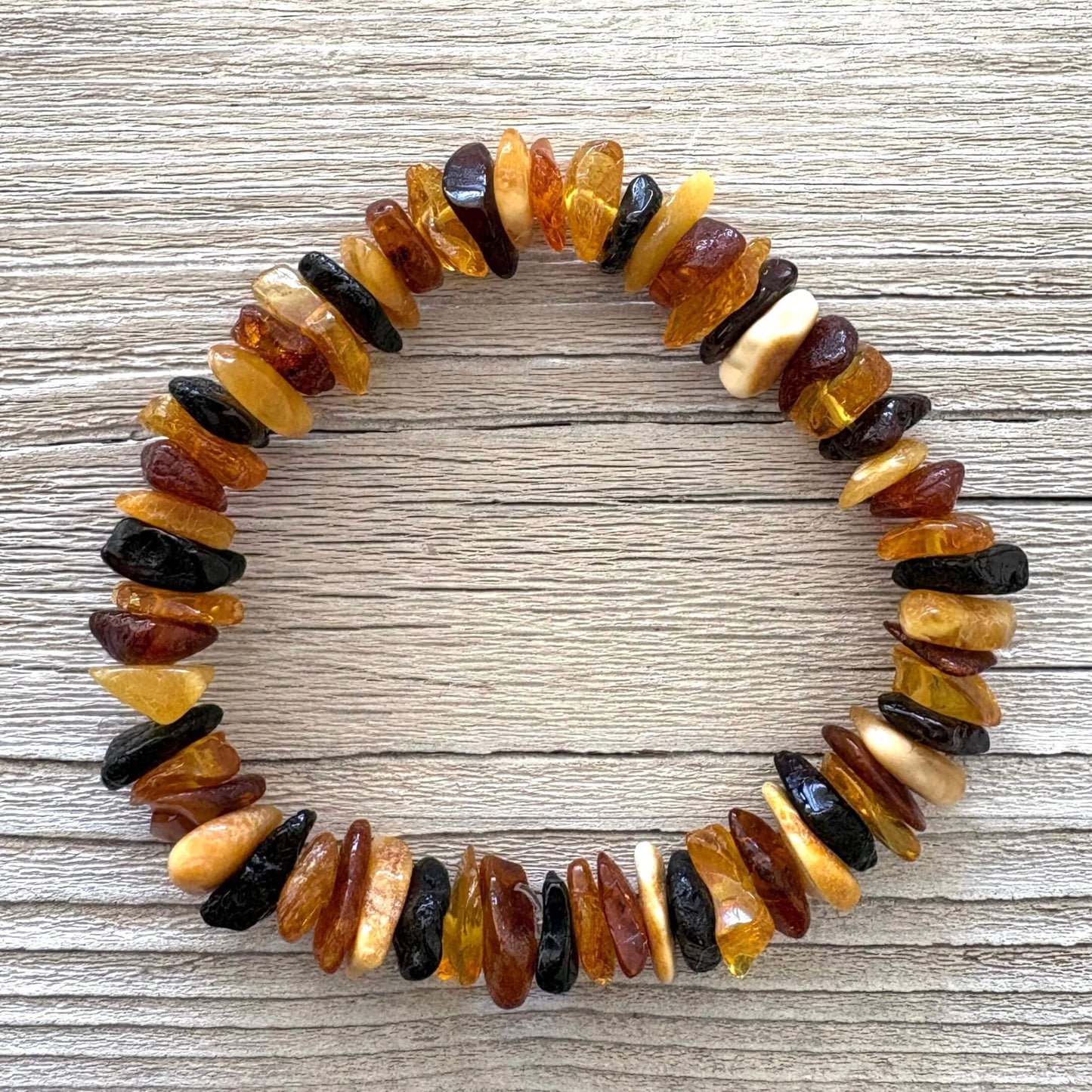 Natural multicolored beaded bracelet on a wooden surface