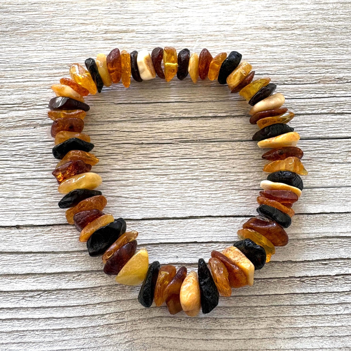 Multicolored amber bracelet on a wooden surface