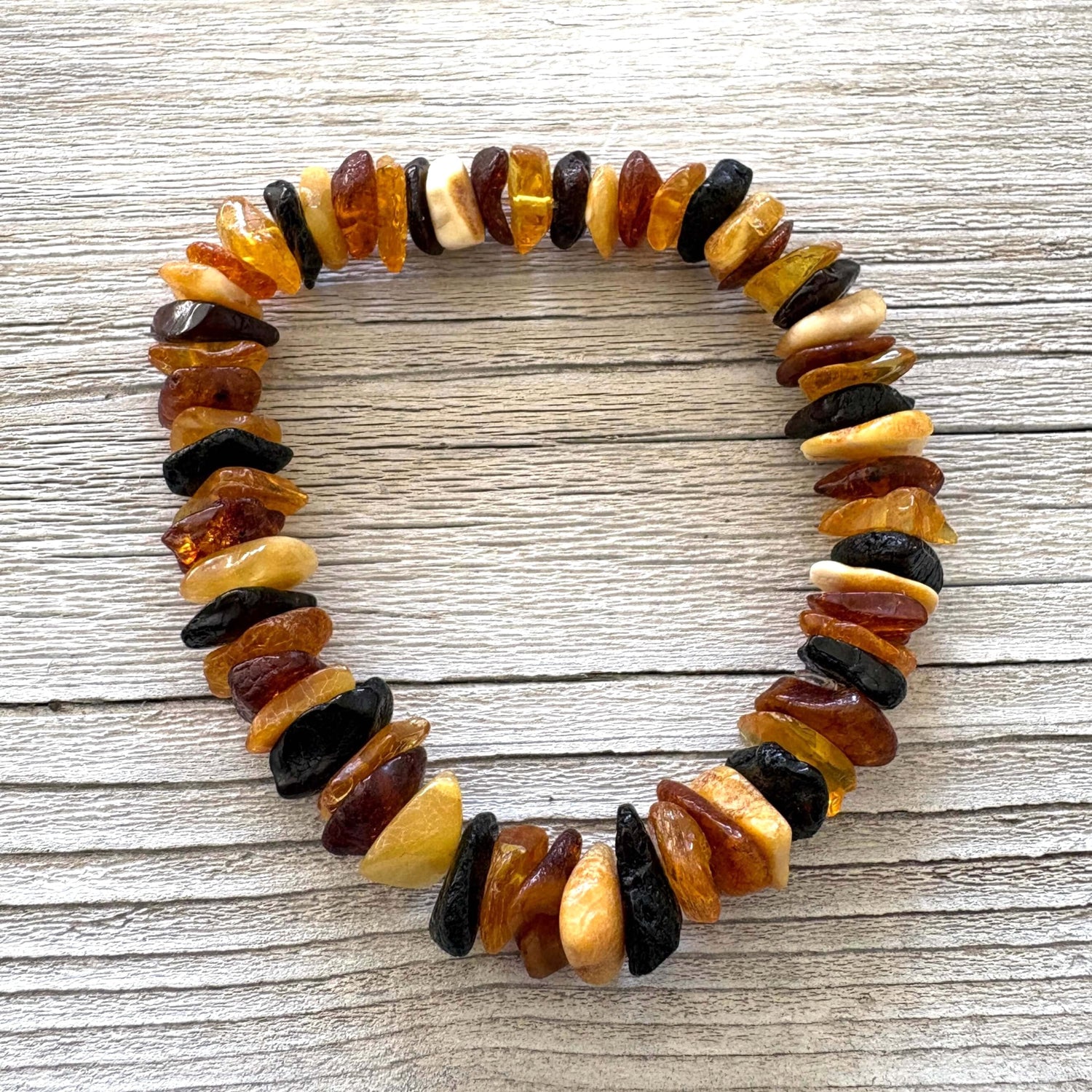 Multicolored amber bracelet on a wooden surface