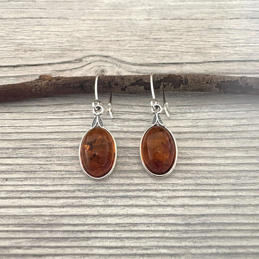 Pair of amber teardrop earrings on a wooden surface