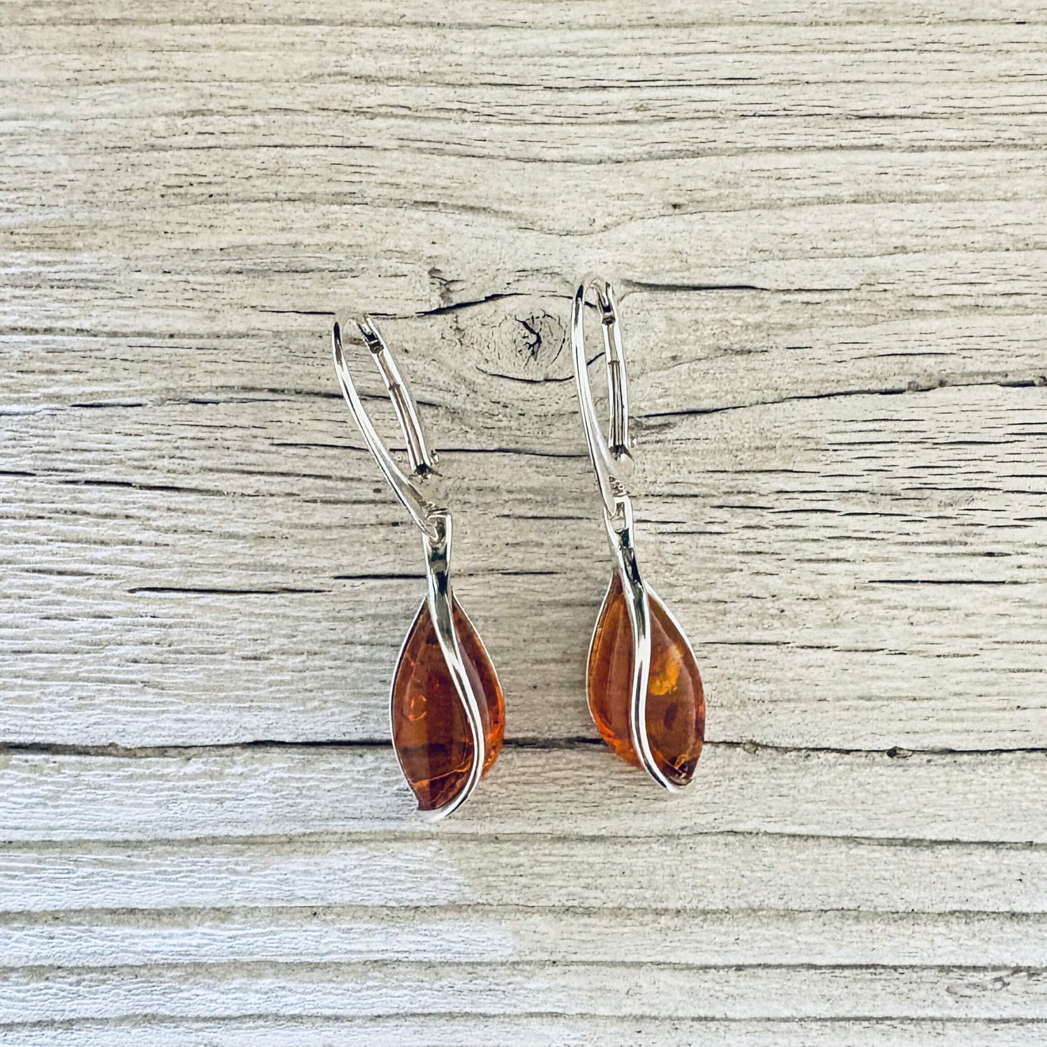Cognac Baltic amber drop earrings with sterling silver twist settings and lever back hooks.