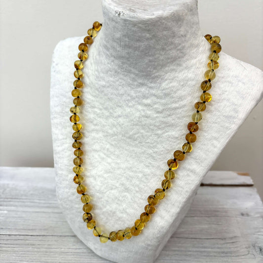 Light green deaded necklace on a mannequin bust with a white background