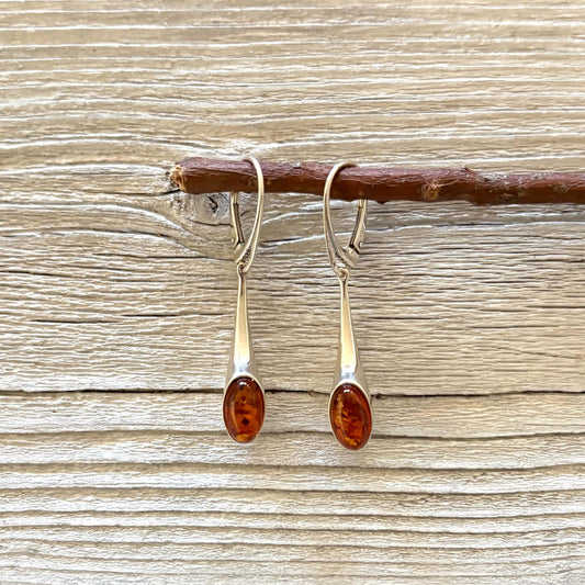 Long sterling silver drop earrings with oval cognac Baltic amber stones.