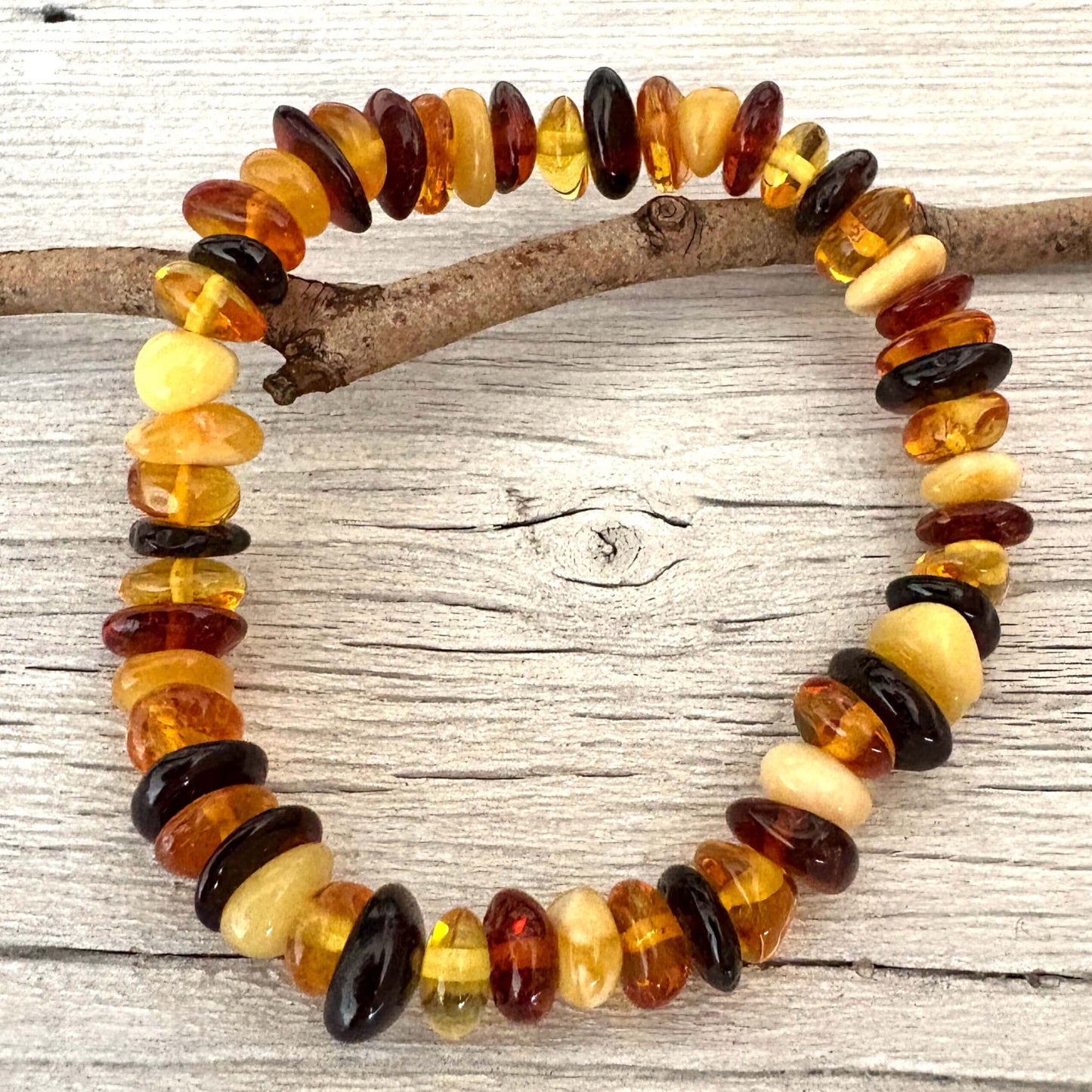 Amber multicolored beaded bracelet on a wooden branch