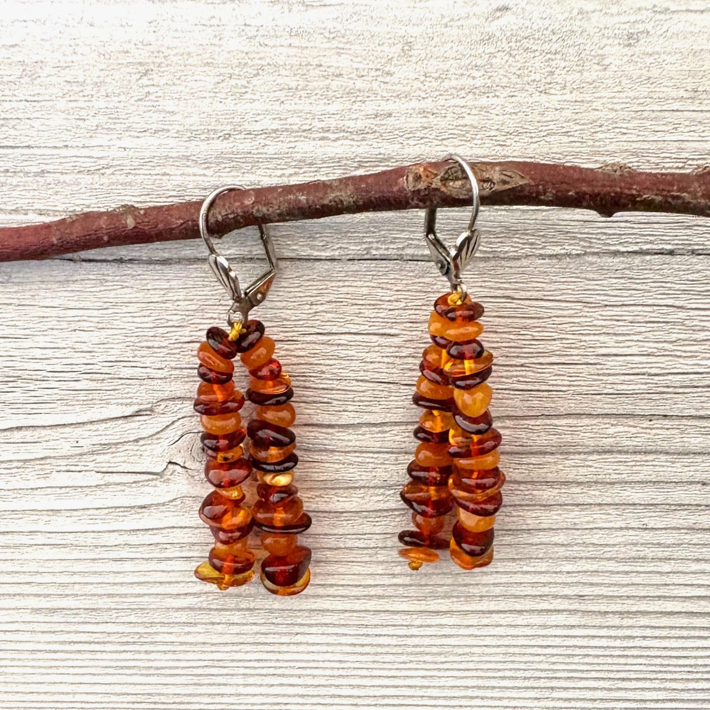 Long elegant amber beaded earrings on a wooden surface