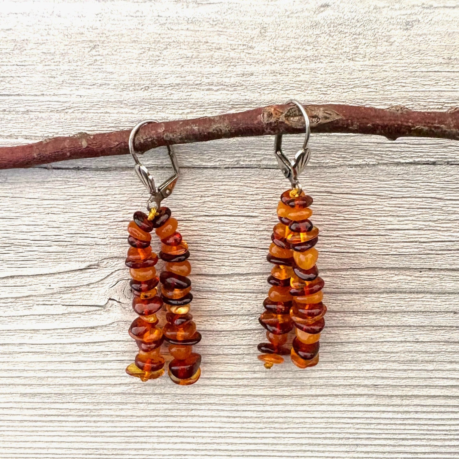 Long elegant amber beaded earrings on a wooden surface