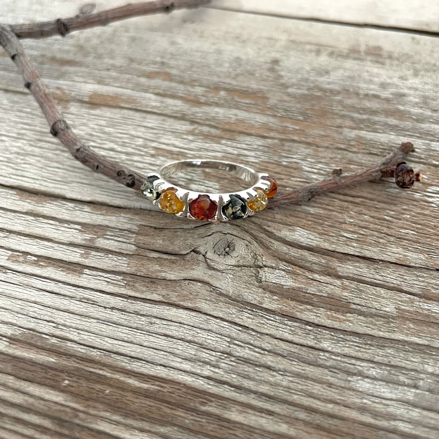 green, yellow and cognac amber round stones set in a sterling silver band