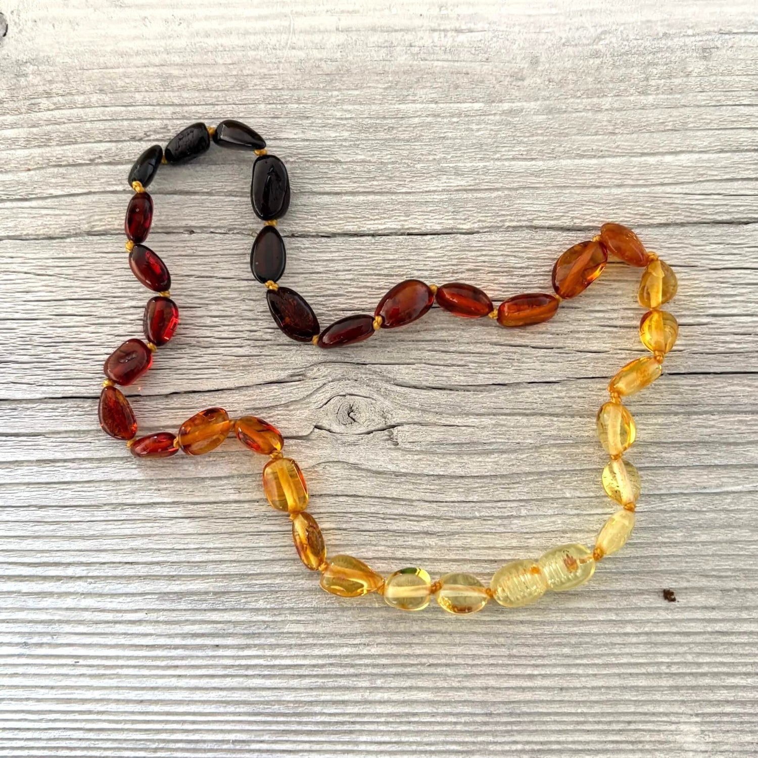 Multicolored amber teething necklace on a wooden surface