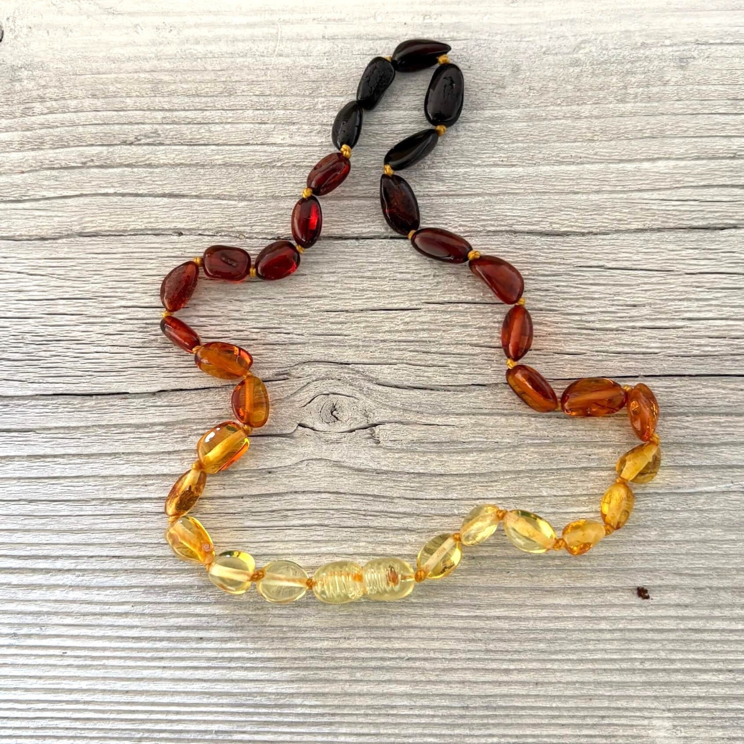 Amber teething necklace on a wooden surface