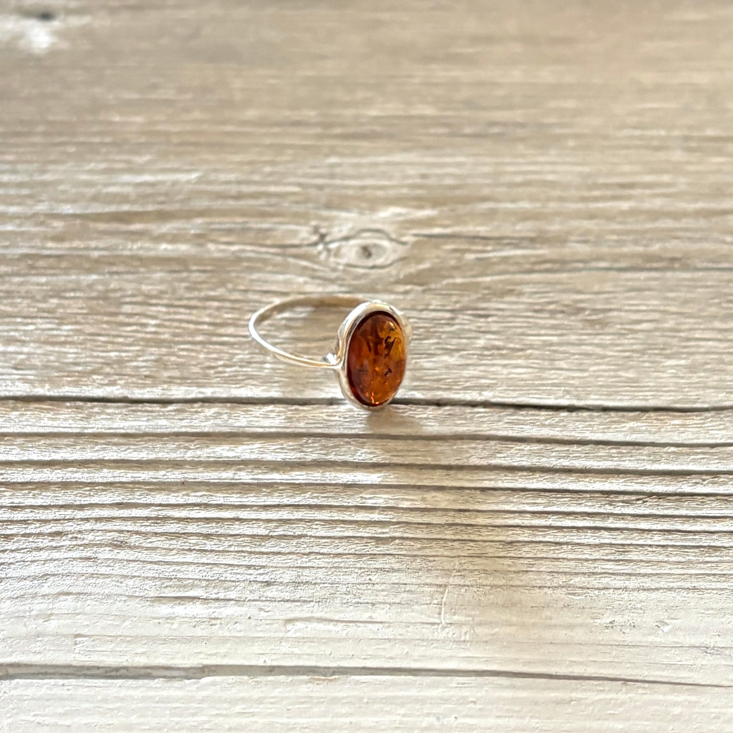 Sterling silver ring with a amber stone on a wooden surface