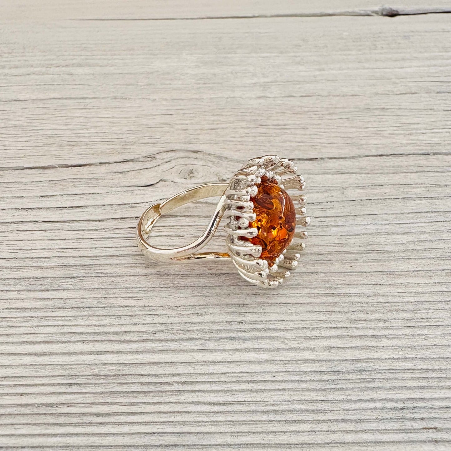 adjustable flower shaped sterling silver ring with a round amber stone