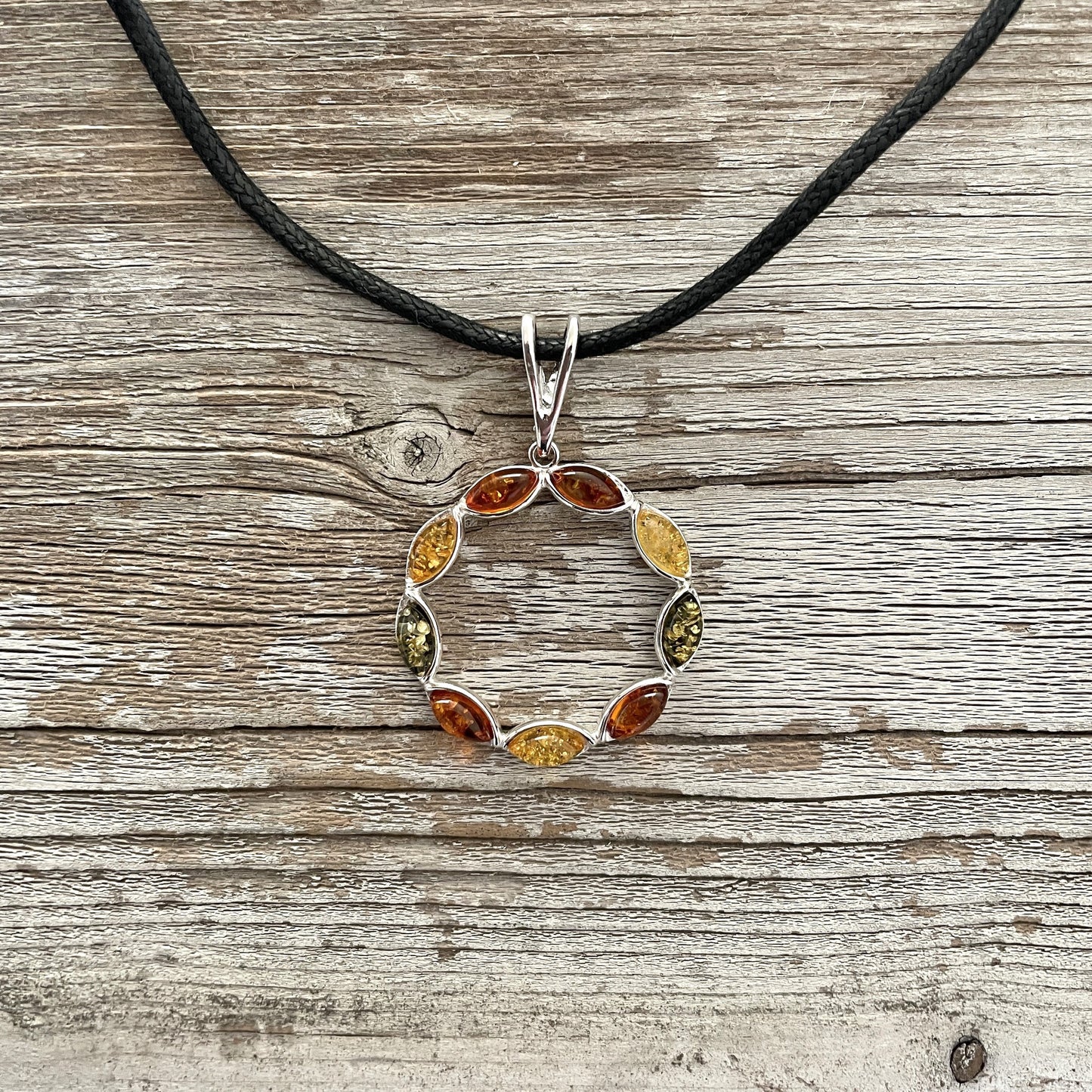 mixed coloured round amber pendant on  black rope 