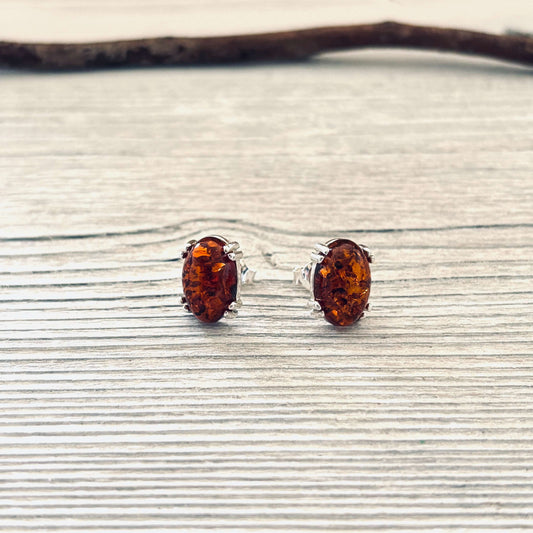 Pair of amber stud earrings on a textured surface