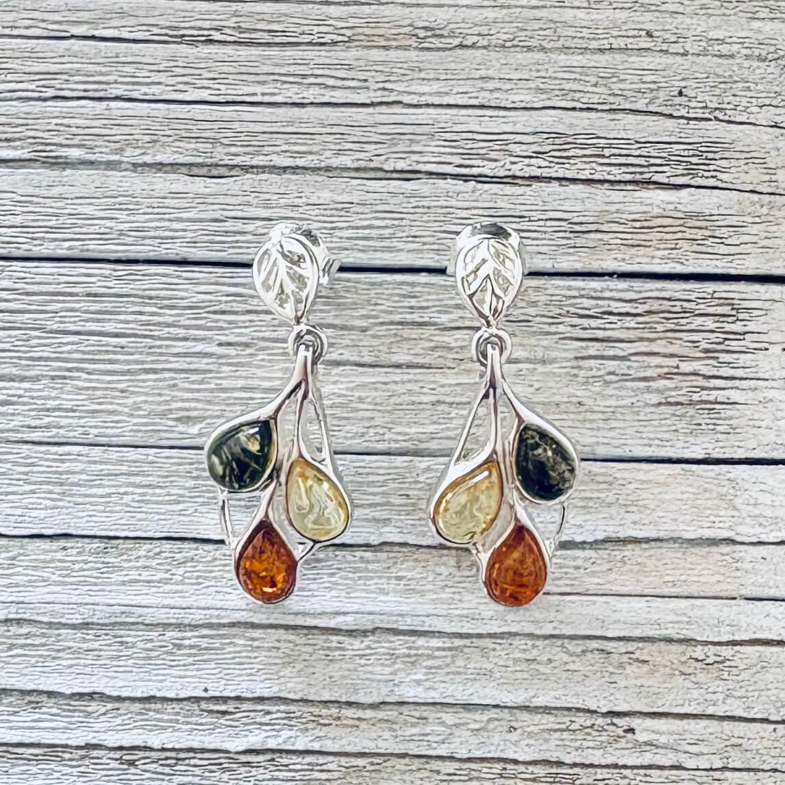 Tricolour Baltic amber drop earrings featuring green , honey and cognac teardrop stones with decorative silver leaf shaped studs.