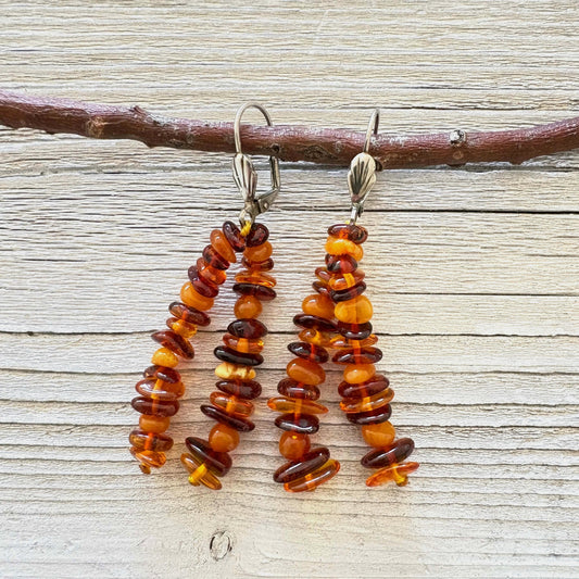 Pair of amber beaded earrings on a wooden surface